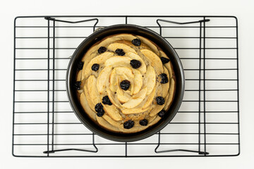 Wall Mural - Top view of round apple cinnamon cake or bread with dried cranberries on cooling rack