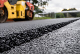 Asphalt road roller with heavy vibration roller compactor press new hot asphalt on the roadway on a road construction site. Heavy Vibration roller at asphalt pavement working. Repairing.