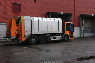 A waste collection vehicle waiting to unload in front of the  gates of a waste treatment facility