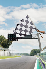 Checkered flag waving on asphalt motorsport circuit finish line