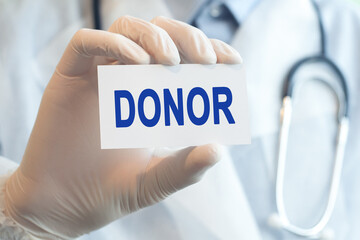 Doctor holding a paper card with text Donor, medical concept