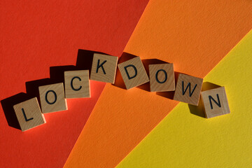 Lockdown, word in wooden alphabet letters isolated onn red, orange and yellow background