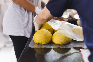 Wall Mural - Female hands hold homemade dough on the table.