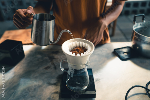 Fotografía Drip coffee, barista pouring water on coffee ground with filter