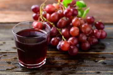 Fresh red grapes fruit and juice on wooden background