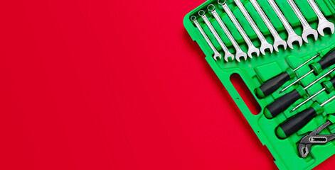 Wall Mural - Green set of construction tools: wrenches, adjustable pliers, screwdriver and so on on a red background. Banner with place for text for a hardware store. Metal hardware for professional repair or DIY