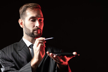 Poster - a man in a business suit holds a tablet horizontally. a businessman with a tablet and stylus in his 