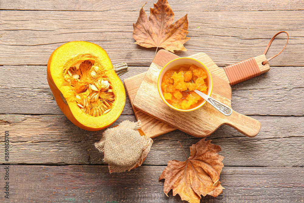Autumn composition with tasty pumpkin jam on wooden background