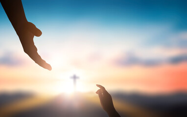  Help hand of God reaching over blurred cross on sunrise  background