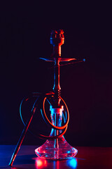 Wall Mural - glass hookah with a metal bowl with hot coals on a black background on a table