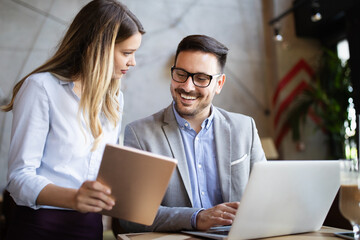 cheerful coworkers in office working and brainstorming together