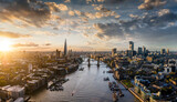 Fototapeta Londyn - Wide panoramic view to the modern skyline of London, United Kingdom, along the Thames river during sunset time