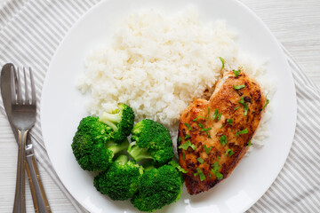 Wall Mural - Homemade Chicken Breast, Rice and Broccoli on a white plate on a white wooden background, top view. Flat lay, overhead, from above.