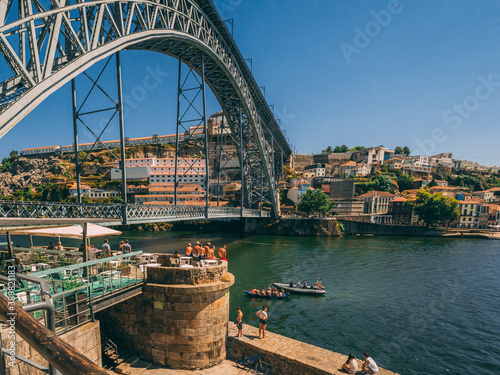 PORTO, PORTUGAL - Jul 18, 2020: Boys jumps from at Dom Luis Bridge into the water