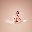 © Artem Popov - sensual woman sitting on light white feather