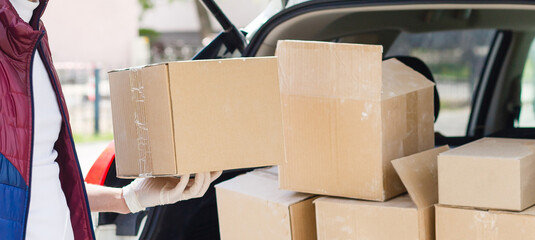 Canvas Print - Delivery man holding paper bag with food near the car, food delivery man in protective mask