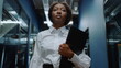 © stockbusters - Afro business woman waving hand in business center. Woman saying hi in office