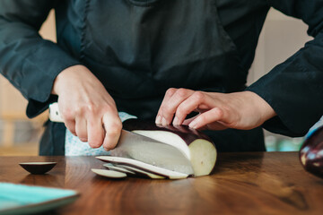 Wall Mural - Close up shot of chef cutting an eggplant