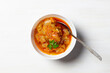 © Natalya - Aubergine appetizer with onion, oil, tomato, garnished with parsley in bowl with spoon on white background