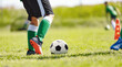 © matimix - Closeup Image of soccer player legs and soccer ball on the field. Fotballers on practice training lesson. Youth athletes on soccer outdooe training