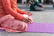© OlgaLitvinovaFoto - Yoga teachers protesting against the blockade and restrictions of Covid-19 in a square in Brescia, Italy. Shot of the hands resting on the knees of the crossed legs. People are meditating.