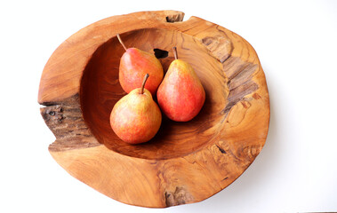 Wall Mural - Three pears in a teak wood bowl on a white background.Natural food. Fruit for juices and jellies.Fruits concept.