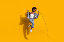 Full Length Photo Of Adorable Young Lady Wear Casual Denim Outfit Jumping Singing Microphone Isolated Yellow Color Background