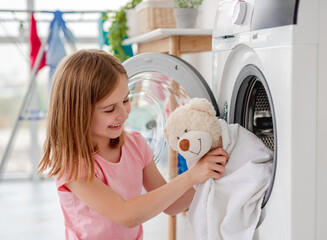 Little girl hugging teddy bear after washing