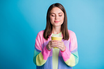 Sticker - Photo of dreamy happy brown haired young woman drink coffee hold mug closed eyes isolated on blue color background