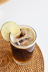 Wall Mural - Espresso tonic in a glass with ice cubes on the white table