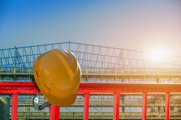 Wall Mural - Orange hard safety helmet hat for safety project of workman as engineer or worker on wooden floor on construction project site background.