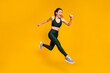 © deagreez - Cheerful lady jump high jogging marathon speed race competitive person wear sports suit shoes isolated yellow color background