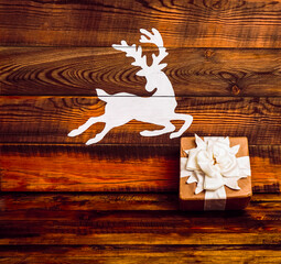 white deer painted on wooden boards. gift box wrapped in craft paper. Happy new year and merry christmas. Holiday background.