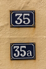 Vintage Style House Numbers 35 And 35a Against A Yellow Wall.