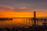 Fototapeta Zachód słońca - warm sunset at a lake with lighthouse