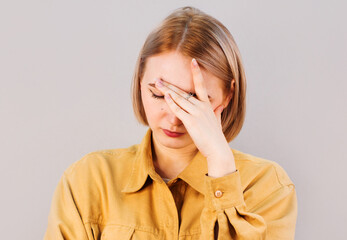 Cute, young beautiful blond hair woman do facepalm. Blond girl headache failed to upset business face palm. Portrait of female doing facepalm posing against studio background.