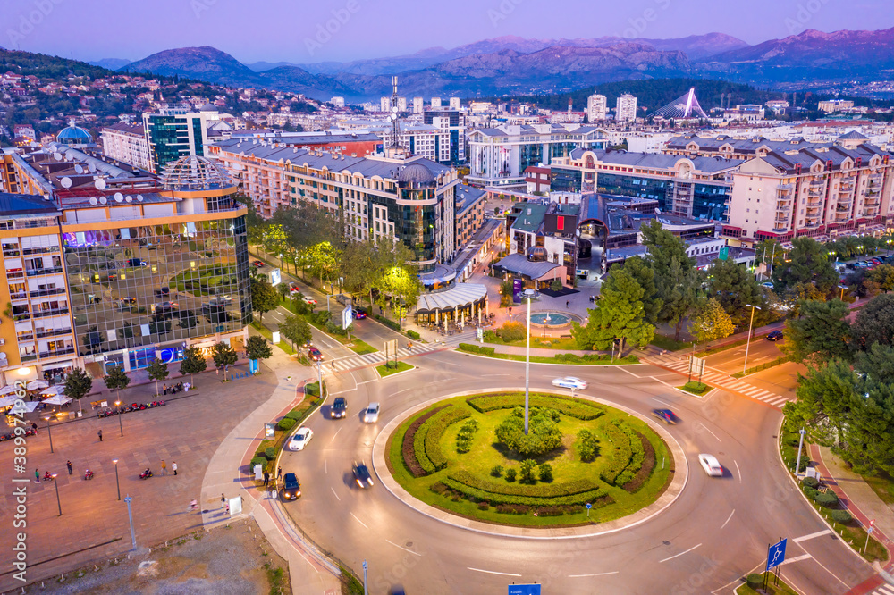 Obraz na płótnie Podgorica Montenegro in the evening. Night cityscape of the capital of a small country in the Balkans, south east Europe. Traffic on roundabout in residential and commercial city center. Aerial view. w salonie