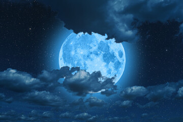 Wall Mural - blue super moon glowing against cloudy sky