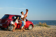 © New Africa - Happy family having fun near car on sandy beach. Summer trip