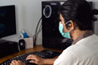 © Nanda - Asian man use surgical mask work on front of computer during pandemic virus situation. People in protective face mask for prevent pandemic virus.