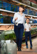 © JackF - Cheerful woman with preteen boy looking for aquarium fishes for in pet store..