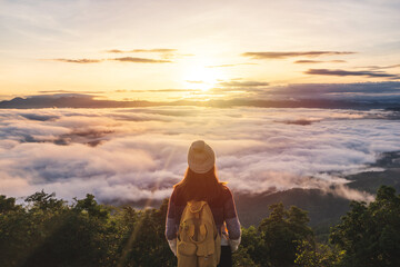 Young woman travelers looking at the sunrise and the sea of mist on the mountain in the morning, Travel lifestyle concept