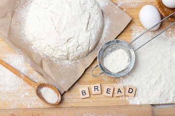 Preparation of dough for home pancakes for Breakfast. Ingredients on the table wheat flour, eggs. inscription bread