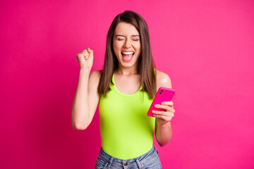 Wall Mural - Photo of crazy lady hold telephone open mouth raise arm close eyes wear green top isolated bright pink color background