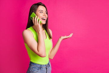 Poster - Portrait of brunette hair girl talk mobile cellphone surprised happy news look empty space isolated over pink color background