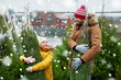 © Syda Productions - family, winter holidays and people concept - happy father and little daughter buying christmas tree at street market over snow