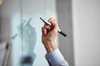© Syda Productions - people, business and corporate concept - close up of hand with marker with sticky notes on glass wall at office
