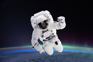 Wall Mural - composite image of astronaut floating in space, earth planet in the background - elements of this im