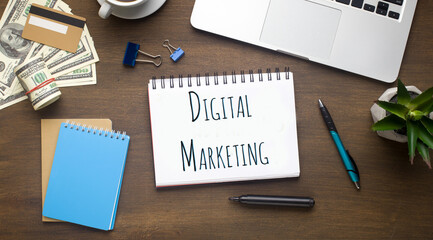 Fototapete - Flat lay of laptop, money and notebook with words DIGITAL MARKETING on office table