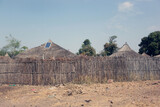 Fototapeta Do akwarium - Basse region, Gambia, Africa - January 19, 2020, wide angle photography of traditional African round huts with  roofs made from high grasses, with a single solar panel on top of one hut,  on sunny day